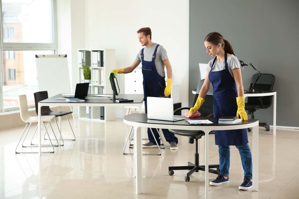 2 Reinigungskräfte reinigen den Tisch